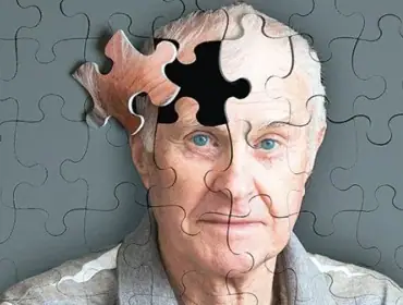 an elderly person wearing a spectacle with his hands on his forehead is looking tensed